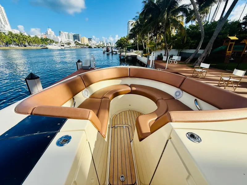 Slide: The Image of 2015 Chris-Craft Launch 32 boat with luxurious seating, docked by a scenic waterfront. - 24