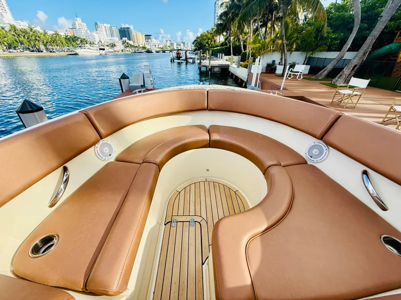 Slide: The Image of 2015 Chris-Craft Launch 32 boat with luxurious seating, docked by a scenic waterfront. - 25