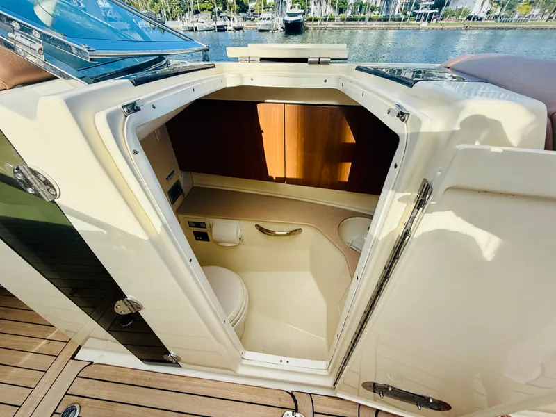 Slide: The Image of 2015 Chris-Craft Launch 32 boat interior with open cabin door, showcasing compact bathroom. - 29