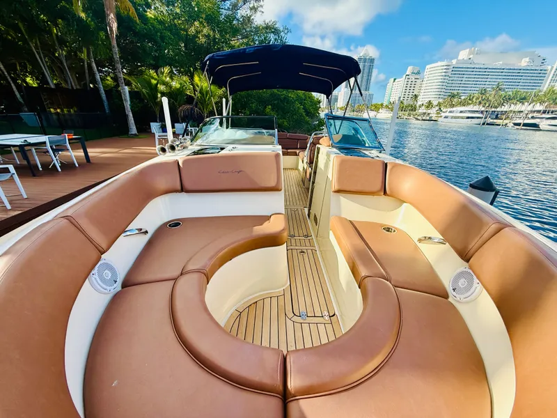 Slide: The Image of 2015 Chris-Craft Launch 32 boat with luxurious seating, docked by a scenic waterfront. - 36