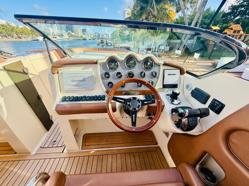 Slide: The Image of 2015 Chris-Craft Launch 32 dashboard with Garmin navigation, wooden steering wheel, and luxurious interior. - 38