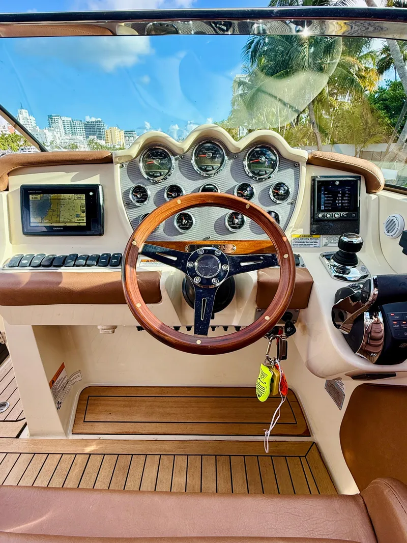 Slide: The Image of 2015 Chris-Craft Launch 32 dashboard with wooden steering wheel and modern controls. - 41