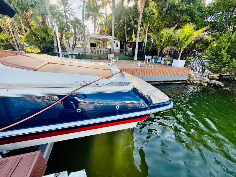 Slide: The Image of 2015 Chris-Craft Launch 32 docked by tropical waterfront with lush greenery. - 8