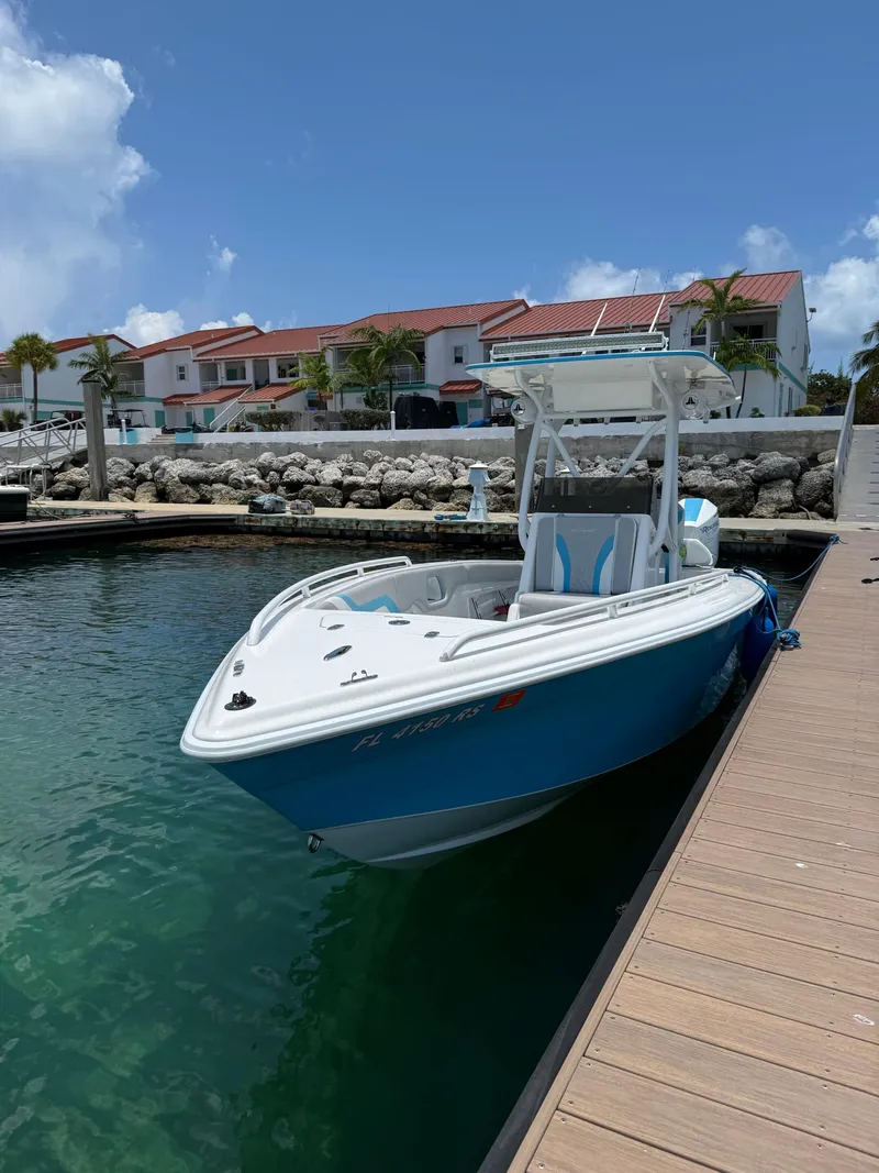 Slide: The Image of 2019 Concept 27' Open Deck boat docked at marina, clear skies, waterfront homes in background. - 4
