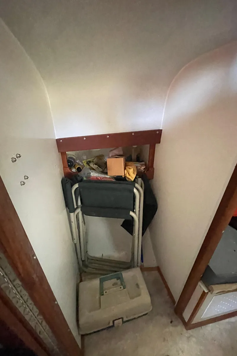 Slide: The Image of Storage area inside a 1995 Stuart Angler 33 Downeast boat with folding chairs and miscellaneous items. - 9