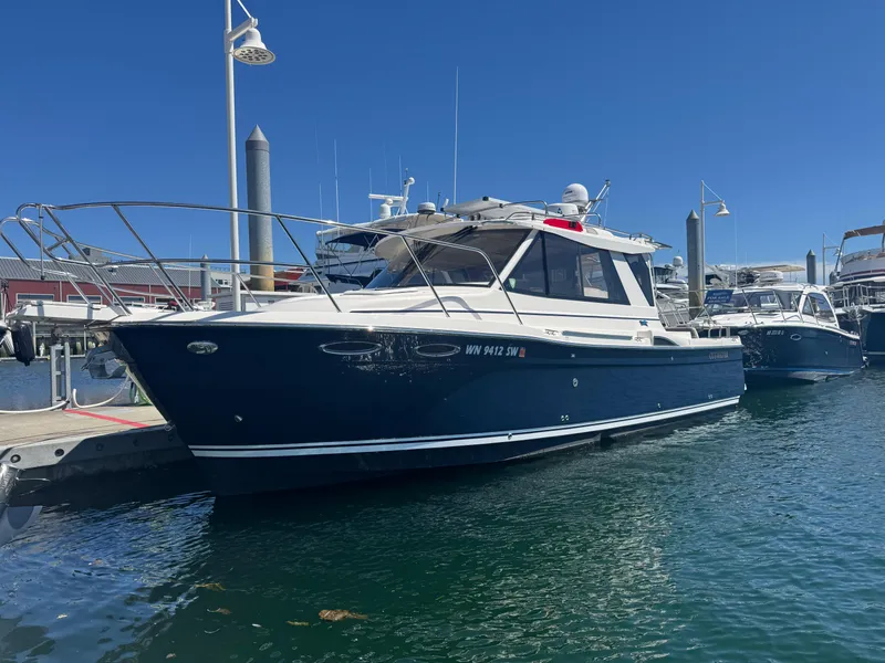 The Image of 2021 Cutwater C-28 boat docked at marina under clear blue sky. - 0