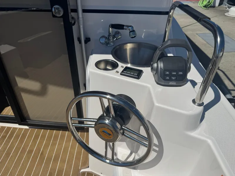 Slide: The Image of 2021 Cutwater C-28 boat helm with steering wheel, sink, and control panel. - 11