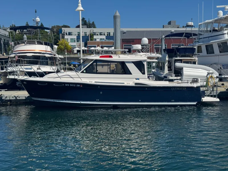 Slide: The Image of 2021 Cutwater C-28 boat docked at a marina under clear blue skies. - 2