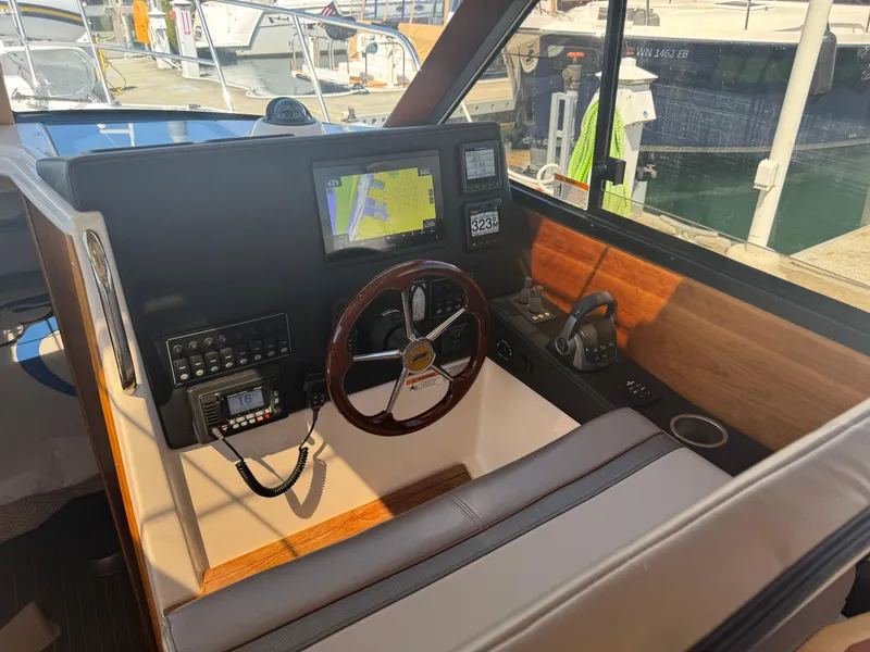Slide: The Image of 2021 Cutwater C-28 helm with navigation display and controls at marina. - 21