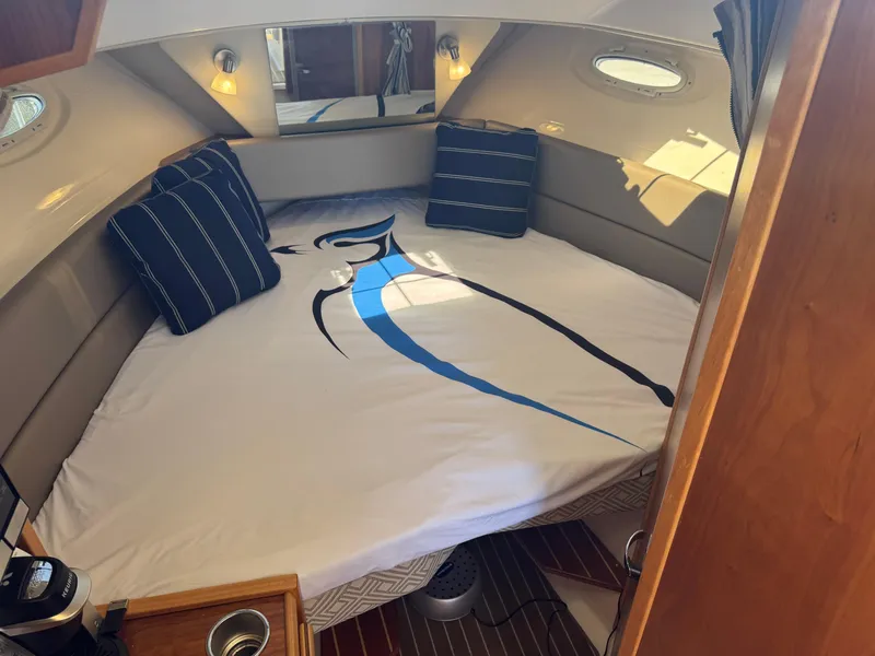 Slide: The Image of 2021 Cutwater C-28 cabin interior with bed and striped pillows. - 26