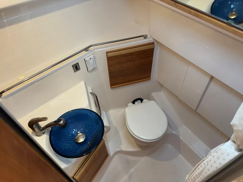 Slide: The Image of 2021 Cutwater C-28 boat bathroom with blue glass sink and modern fixtures. - 27