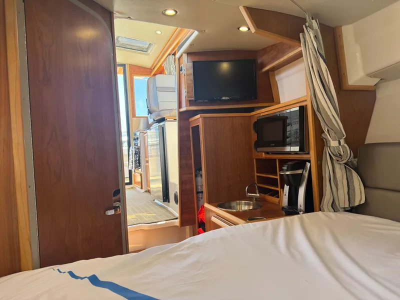 Slide: The Image of Interior of 2021 Cutwater C-28 boat with kitchenette, TV, and bed. - 28