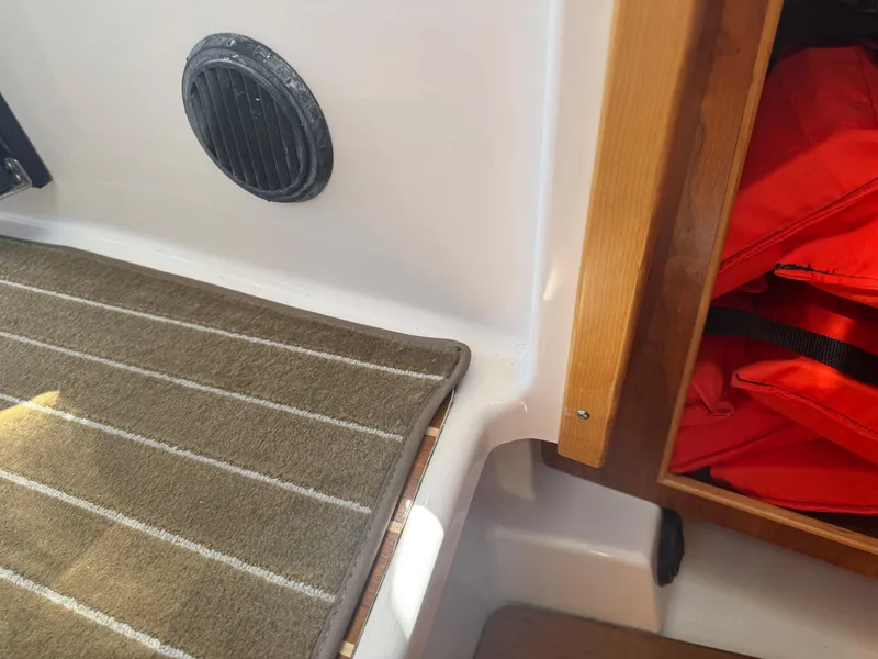 Slide: The Image of 2021 Cutwater C-28 interior with carpet, vent, and life jackets in storage. - 29