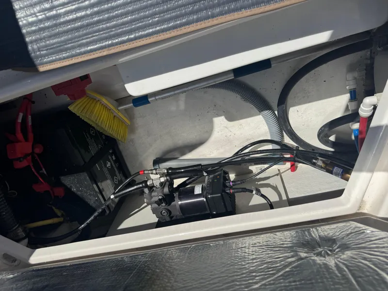 Slide: The Image of 2021 Cutwater C-28 boat storage compartment with wiring, battery, and cleaning brush. - 38