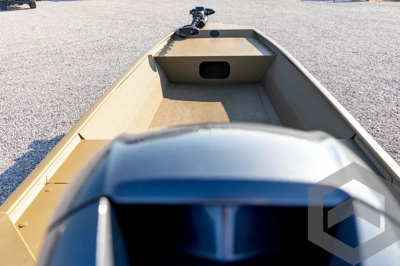 Slide: The Image of 2025 G3 Gator Tough 1652 VBW boat interior with motor, on gravel surface. - 49