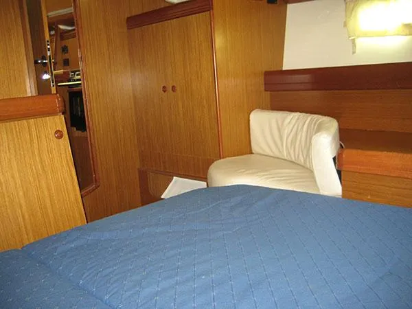 Slide: The Image of Interior of 2006 Jeanneau Sun Odyssey 42 DS with wooden paneling and blue bedding. - 10