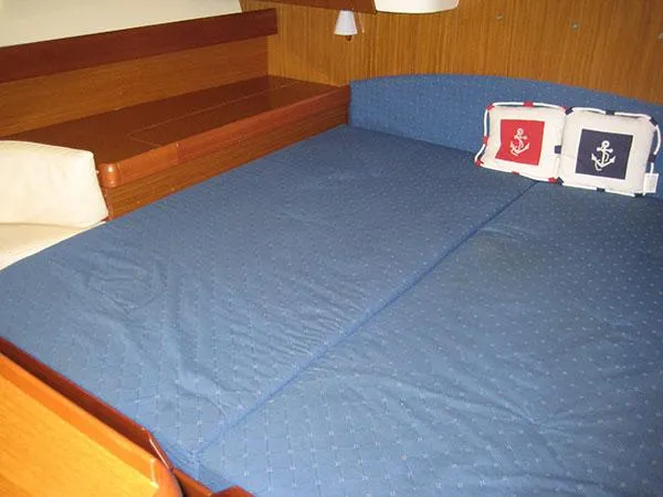Slide: The Image of Interior cabin of 2006 Jeanneau Sun Odyssey 42 DS with blue bedding and nautical-themed pillows. - 17