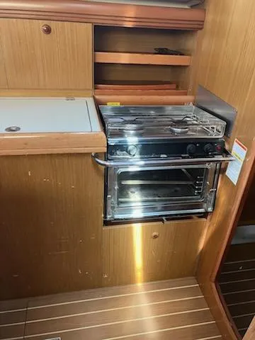 Slide: The Image of 2006 Jeanneau Sun Odyssey 42 DS yacht kitchen with stove and wooden cabinetry. - 21