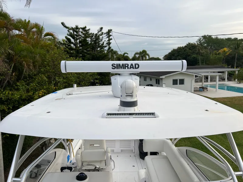 Slide: The Image of 2008 Pro-Line 32 Express boat with Simrad radar, docked near a modern house and pool. - 10