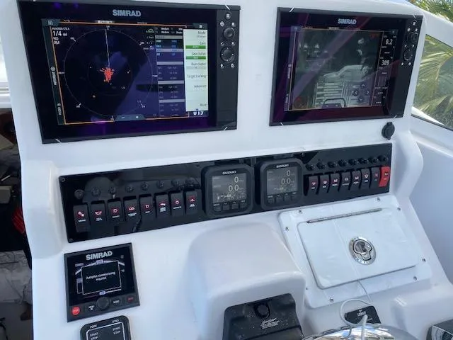 Slide: The Image of 2008 Pro-Line 32 Express boat dashboard with Simrad navigation displays and control panels. - 8