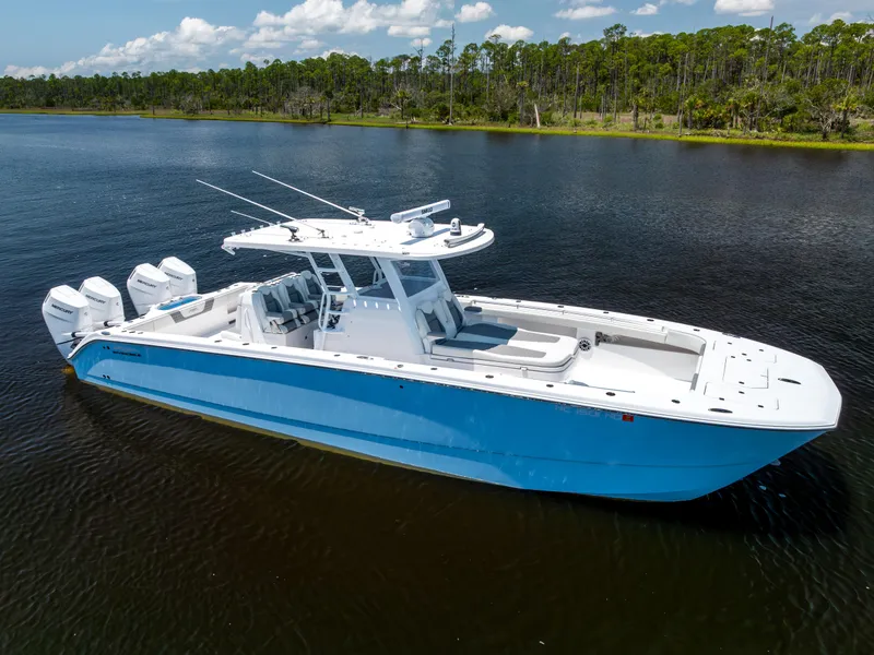 Slide: The Image of 2024 Invincible 37 Catamaran in blue, docked on calm water, with four outboard engines. - 15