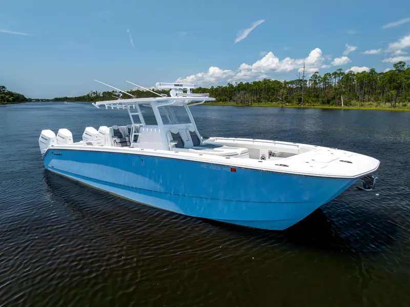 Slide: The Image of 2024 Invincible 37 Catamaran in blue, cruising on a serene lake under a clear sky. - 17