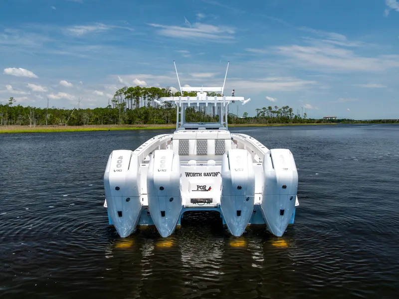 Slide: The Image of 2024 Invincible 37 Catamaran with quad 400 V10 engines on a serene waterway. - 18