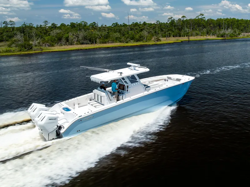 Slide: The Image of 2024 Invincible 37 Catamaran cruising on a scenic waterway under a clear sky. - 23