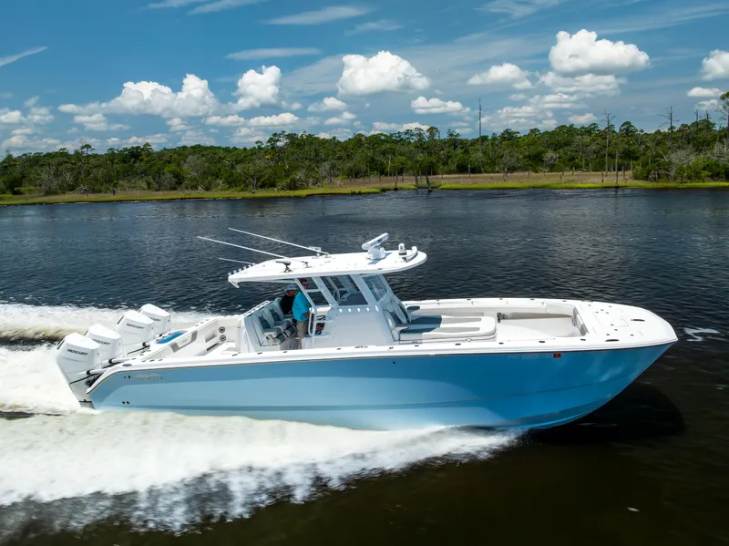 Slide: The Image of 2024 Invincible 37 Catamaran cruising on a scenic waterway under a clear blue sky. - 24