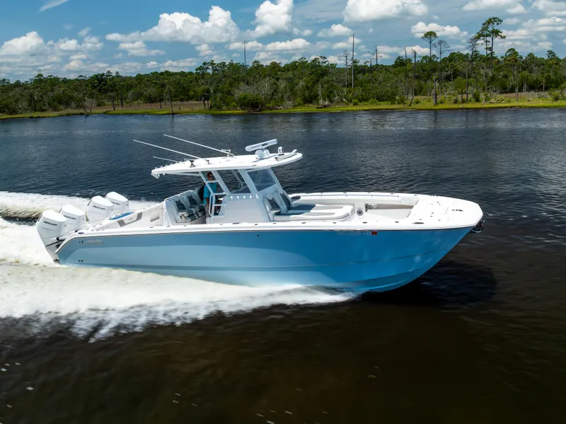 Slide: The Image of 2024 Invincible 37 Catamaran cruising on a scenic river under a clear blue sky. - 26