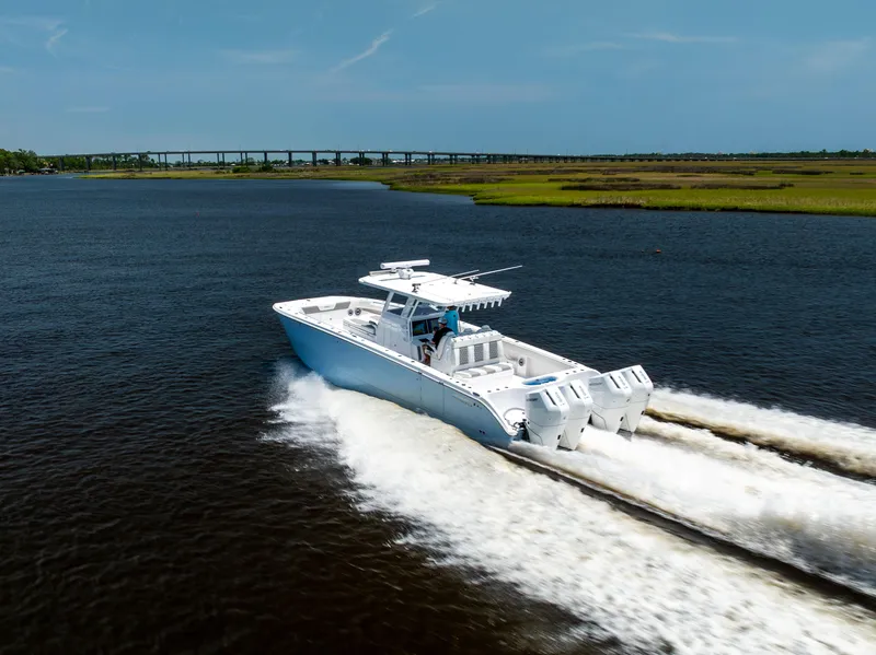 Slide: The Image of 2024 Invincible 37 Catamaran cruising on water with scenic bridge in background. - 28