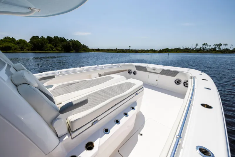 Slide: The Image of 2024 Invincible 37 Catamaran boat interior with cushioned seating on calm water. - 31