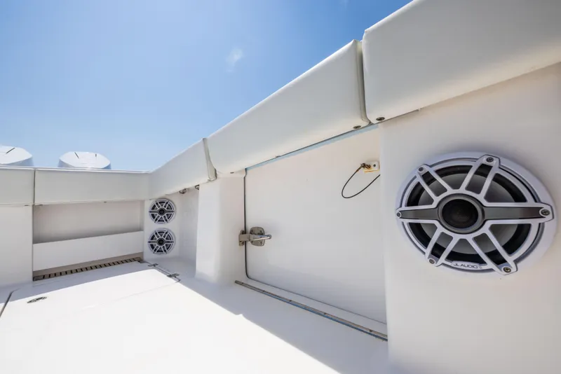 Slide: The Image of 2024 Invincible 37 Catamaran with JL Audio speakers, white interior, and clear blue sky. - 46