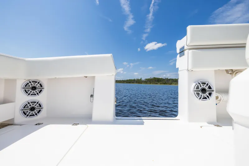 Slide: The Image of 2024 Invincible 37 Catamaran deck view with speakers, overlooking serene water and blue sky. - 48