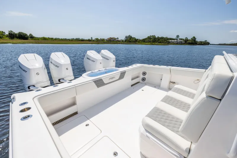 Slide: The Image of 2024 Invincible 37 Catamaran with four Mercury engines on a serene waterway. - 49