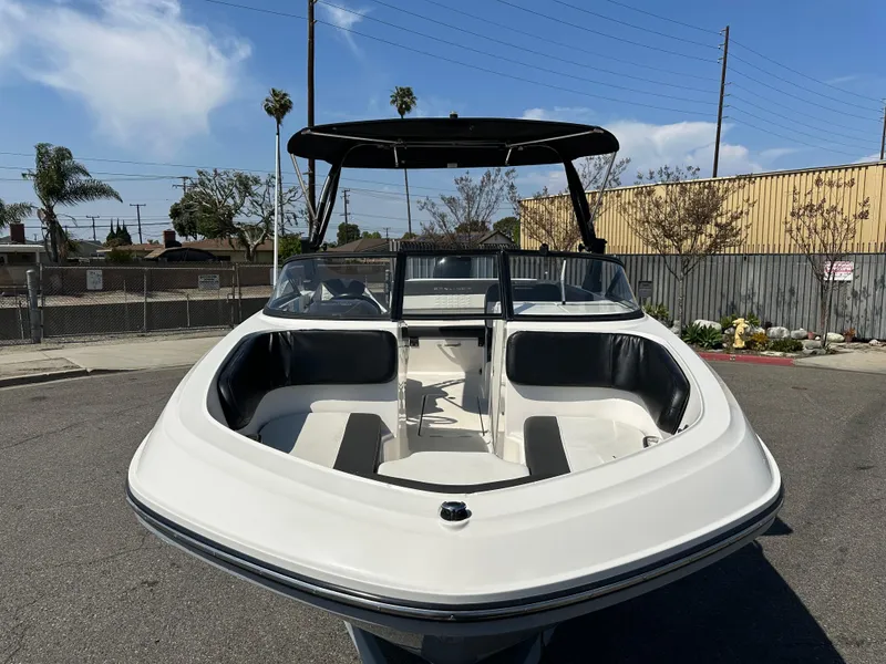 Slide: The Image of 2020 Bayliner VR6 Bowrider OB boat with black canopy in a parking lot. - 7