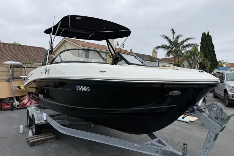 The Image of 2022 Bayliner VR6 Bowrider OB on trailer, parked in residential area. - 1