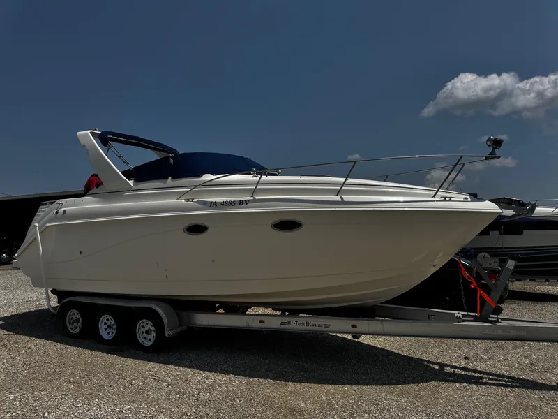 The Image of 2000 Rinker 270 Express Cruiser on trailer under clear sky. - 1