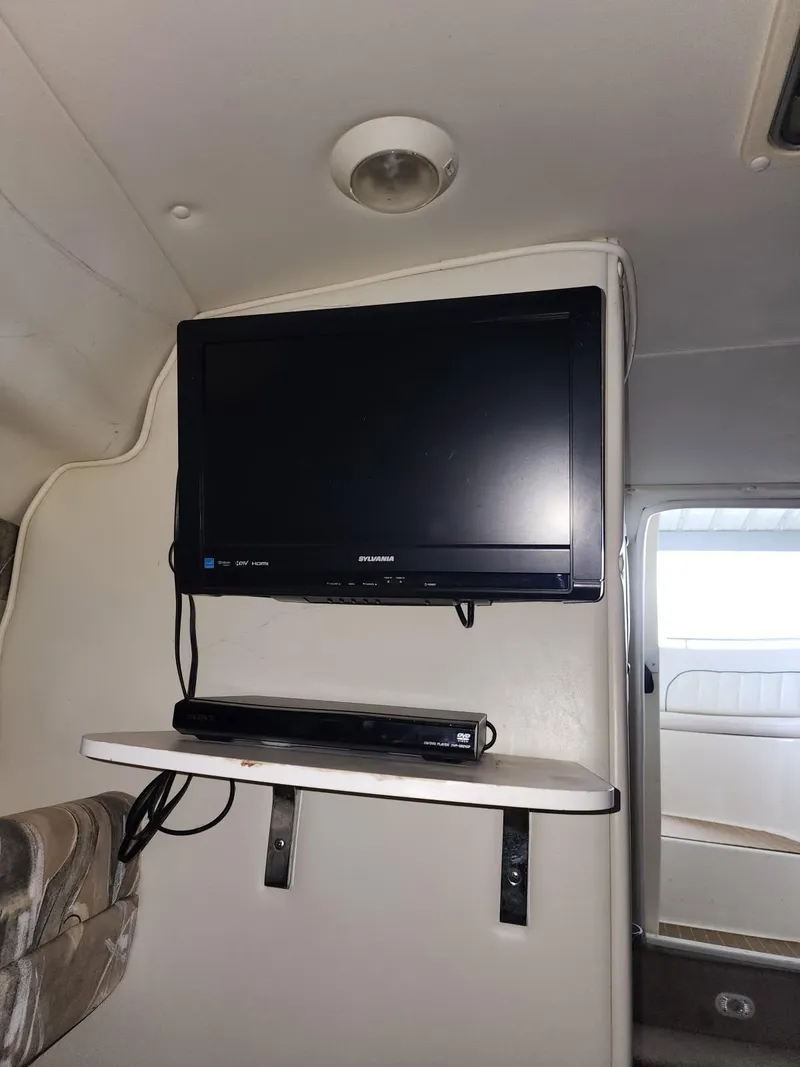 Slide: The Image of Interior of 2000 Rinker 270 Express Cruiser with mounted TV and DVD player. - 16