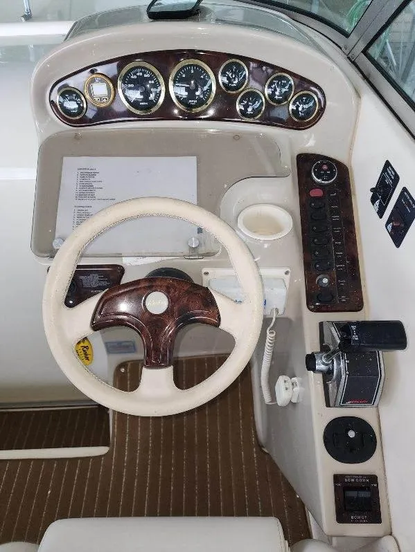 Slide: The Image of 2000 Rinker 270 Express Cruiser dashboard with steering wheel and control panel. - 24