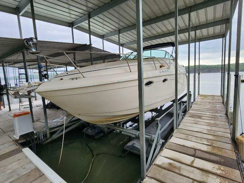 Slide: The Image of 2000 Rinker 270 Express Cruiser docked in a covered marina. - 25