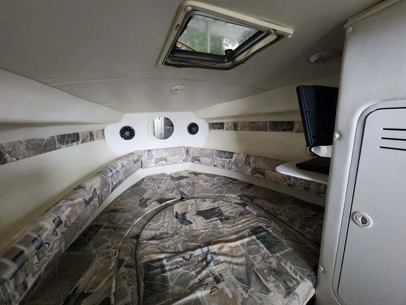 Slide: The Image of Interior cabin of 2000 Rinker 270 Express Cruiser with patterned upholstery and porthole window. - 7