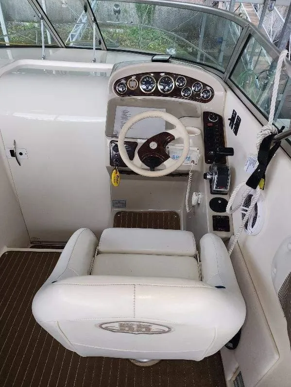 Slide: The Image of Cockpit of 2000 Rinker 270 Express Cruiser with steering wheel and control panel. - 9