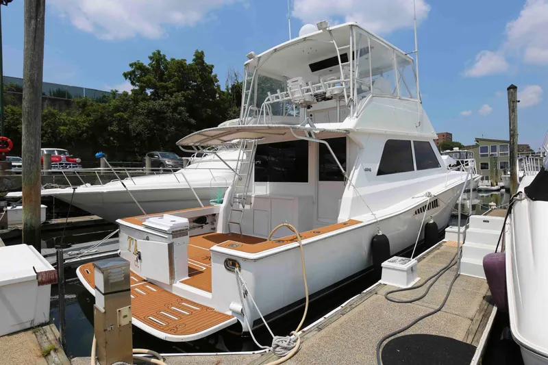 The Image of 1991 Viking 50 Convertible yacht docked at marina, featuring spacious deck and flybridge. - 0