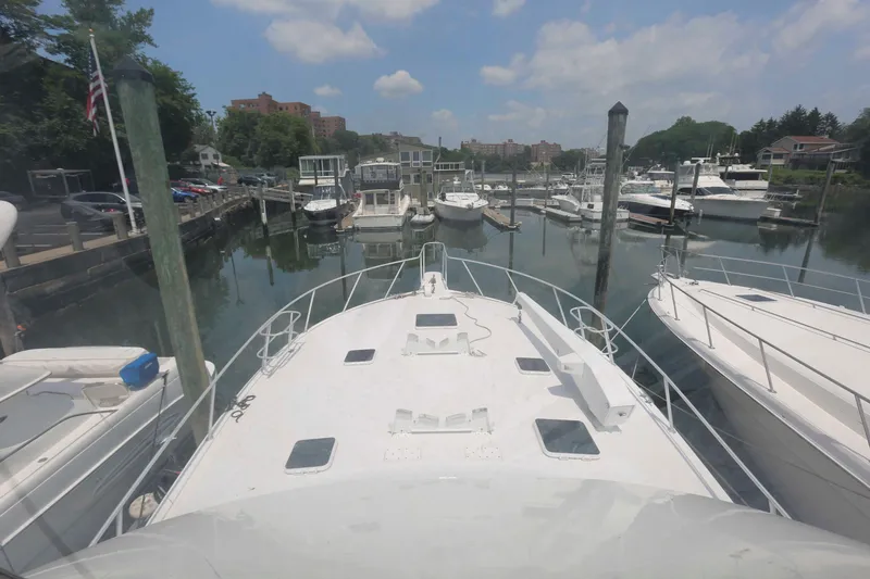 Slide: The Image of Bow view of a 1991 Viking 50 Convertible yacht docked in a marina. - 16