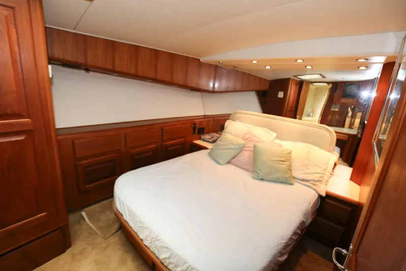 Slide: The Image of Luxurious bedroom interior of 1991 Viking 50 Convertible yacht with wood paneling and cozy bedding. - 27