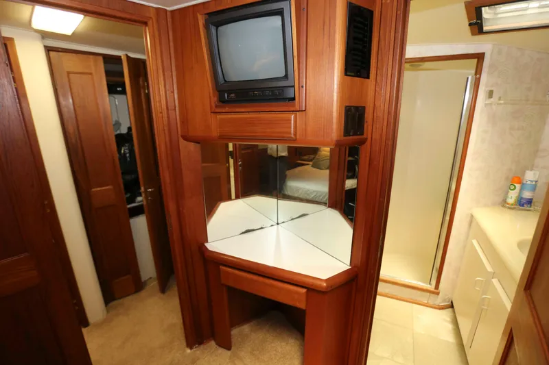 Slide: The Image of 1991 Viking 50 Convertible yacht interior with TV, mirror, and wooden cabinetry. - 32