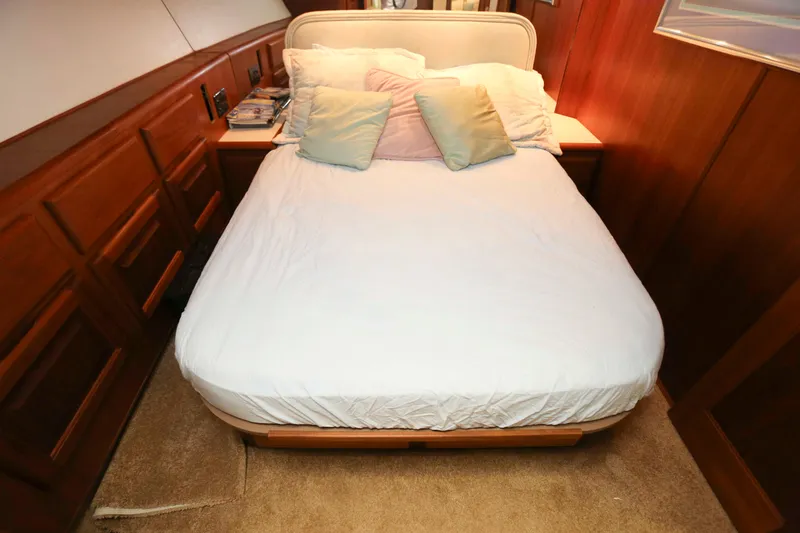 Slide: The Image of Cozy bedroom in 1991 Viking 50 Convertible yacht with wooden paneling and plush bedding. - 33