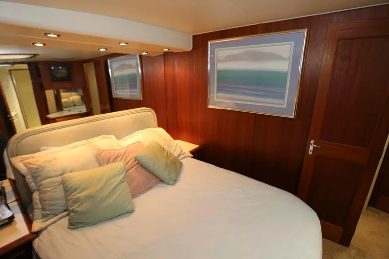 Slide: The Image of Cozy bedroom interior of 1991 Viking 50 Convertible yacht with wood paneling and soft lighting. - 34