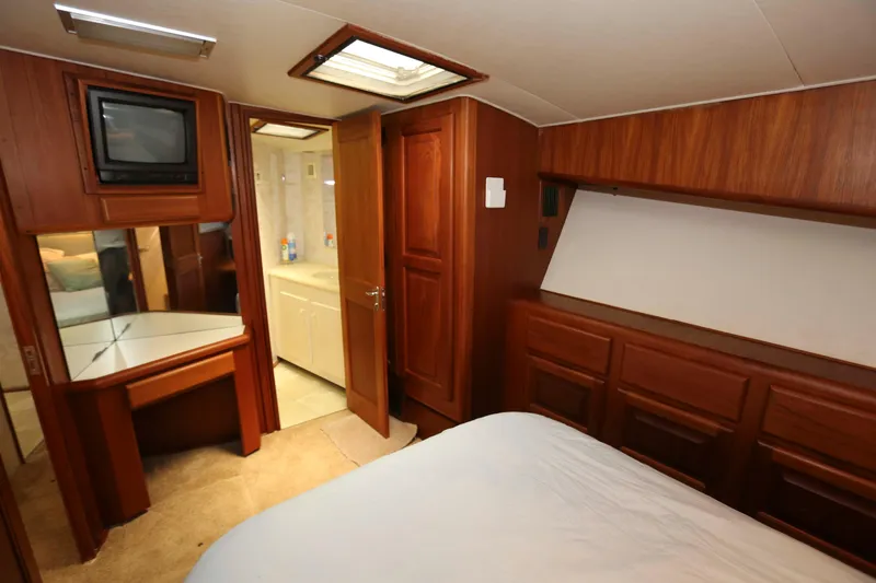 Slide: The Image of Interior of 1991 Viking 50 Convertible yacht with wood paneling and compact bathroom. - 35